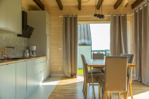 a kitchen and dining room with a table and chairs at Jaśminowy Sad in Mikołajki