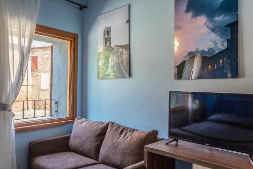 a living room with a couch and a flat screen tv at Malatesta Antica Dimora in Longiano