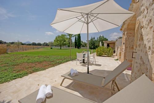a white umbrella sitting on top of a wooden table at Agroturisme Rafal Nou in Manacor