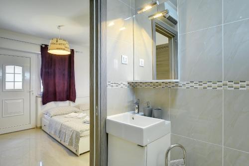 a bathroom with a sink and a mirror and a bed at Diegos Apartments in Pula