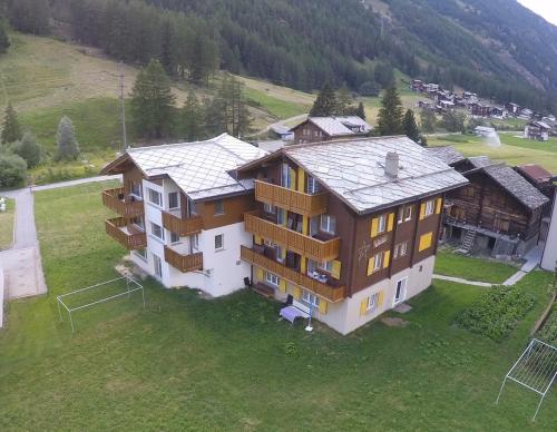 an aerial view of a large house in a field at Haus Weideli, Dammstrasse 7 in Saas-Grund