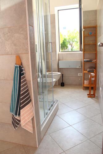 a bathroom with a shower and a toilet and a window at Casa Laura in Imperia