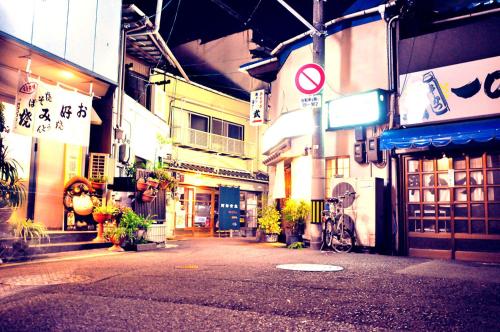 an empty street in an asian city at night at SIMA inn in Onomichi