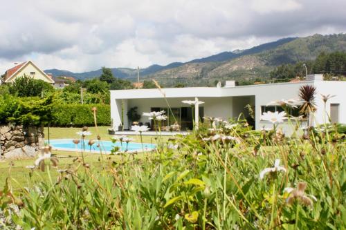 a villa with a swimming pool and mountains in the background at Casa Vale da Cortinha - Near Gerês in Vieira do Minho