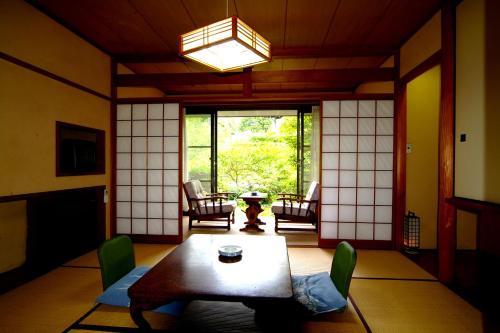 a living room with a table and chairs and a window at Mitake in Hakone