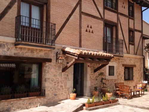 a brick building with a porch and a patio at El Rincón de Rascafría in Rascafría