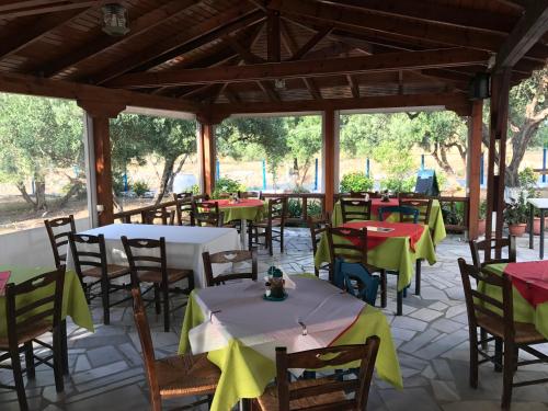 an empty patio with tables and chairs in a restaurant at Tholos Rooms in Kavoúsion