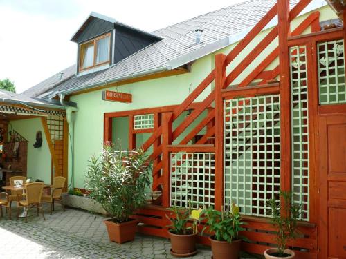 a wooden fence in front of a house with plants at Penzion U Šelongů in Jindrichuv Hradec