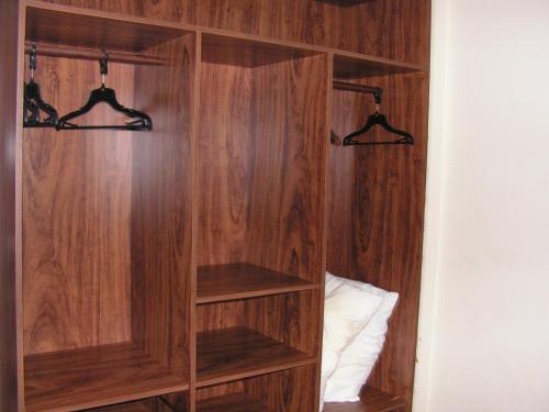 a wooden book shelf with hangers in a bedroom at Blue Marlin Resort&Spa in Parnamirim