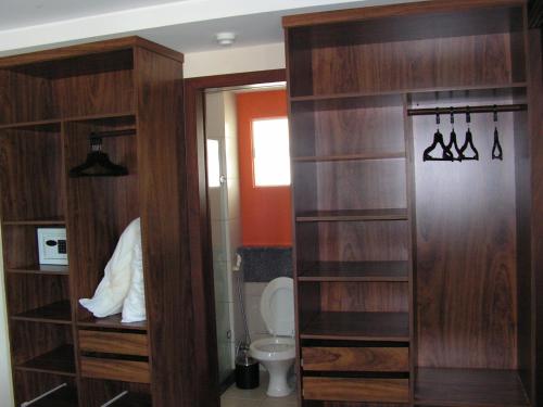 La salle de bains est pourvue d'étagères en bois et de toilettes. dans l'établissement Blue Marlin Resort&Spa, à Parnamirim