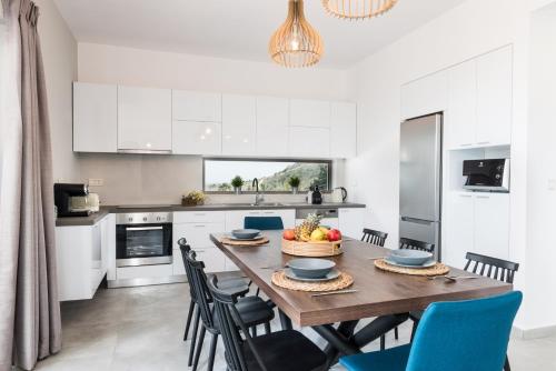 a kitchen and dining room with a wooden table and chairs at NiMar Villas in Plaka