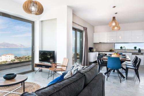 a living room with a couch and a kitchen with a view at NiMar Villas in Plaka