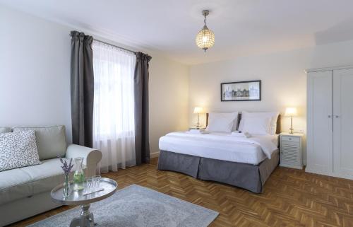 a bedroom with a white bed and a couch at Pałacyk Szklarska in Piechowice