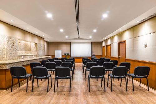 a conference room with chairs and a white screen at Eurostars Zona Rosa Suites in Mexico City