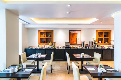 a restaurant with tables and chairs and a counter at Eurostars Zona Rosa Suites in Mexico City
