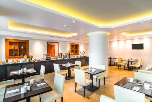a restaurant with tables and chairs and a bar at Eurostars Zona Rosa Suites in Mexico City