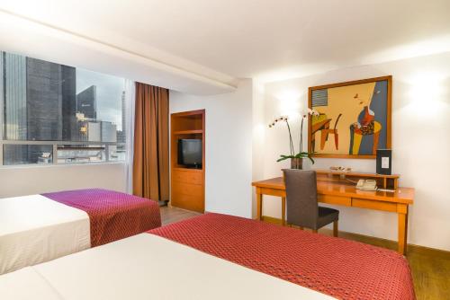 a hotel room with a desk and a bed at Eurostars Zona Rosa Suites in Mexico City
