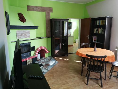 a living room with a table and a fireplace at Penzion Libertas Mariánské Lázně in Mariánské Lázně