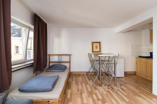 ein kleines Zimmer mit einem Bett und einem Tisch in der Unterkunft Oldtown Apartment Andreasstrasse in Düsseldorf