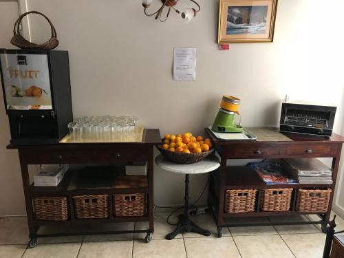 une chambre avec deux tables et un bol d'oranges dans l'établissement Logis Hôtel restaurant Les Minotiers, à Mirepoix