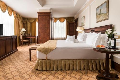 pokój hotelowy z dużym łóżkiem i stołem w obiekcie Nobil Luxury Boutique Hotel w Kiszyniowie