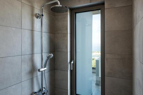 a shower in a bathroom with a glass door at NiMar Villas in Plaka
