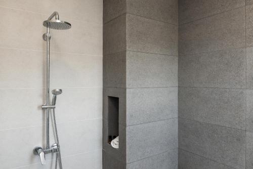 a bathroom with a shower with a shower head at NiMar Villas in Plaka