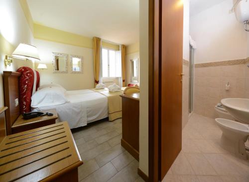 a hotel room with a bed and a toilet at Hotel & Terme Bagni di Lucca in Bagni di Lucca
