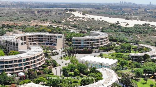 an aerial view of a campus with buildings and a river at Neot Golf, Ziv's Place in Caesarea