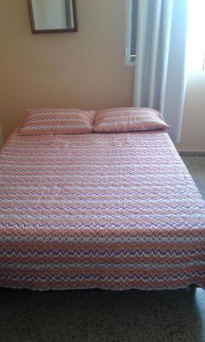 1 cama con edredón naranja y blanco en un dormitorio en Leohome, en Melo