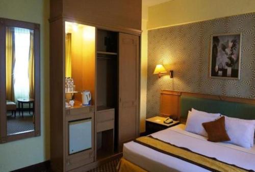 a hotel room with a bed and a window at Ratu Mayang Garden in Pekanbaru