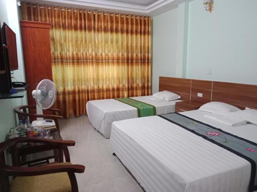 a hotel room with two beds and a fan at Ruby Hostel Hà Giang in Ha Giang
