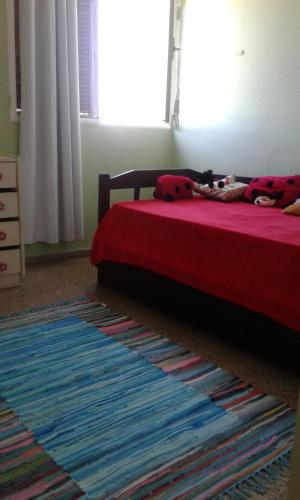 Leohome في ميلو: غرفة نوم بسرير وبطانية حمراء وسجادة