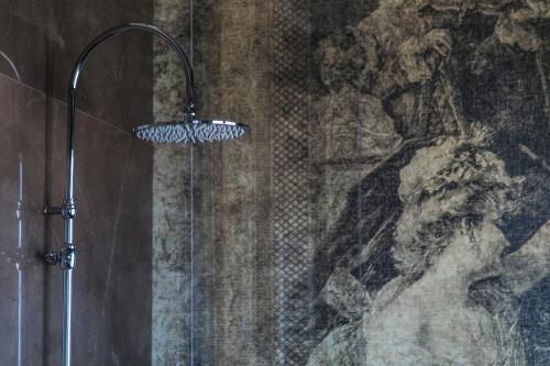 a shower in a bathroom with a painting on the wall at Hotel Villa Pascucci in Durrës