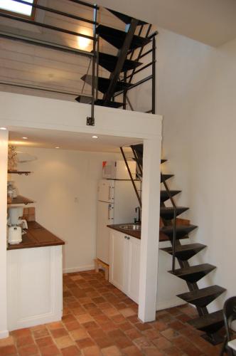 une cuisine avec un escalier en colimaçon dans une pièce dans l'établissement La Vallière en Vue - gîte climatisé, à Amboise
