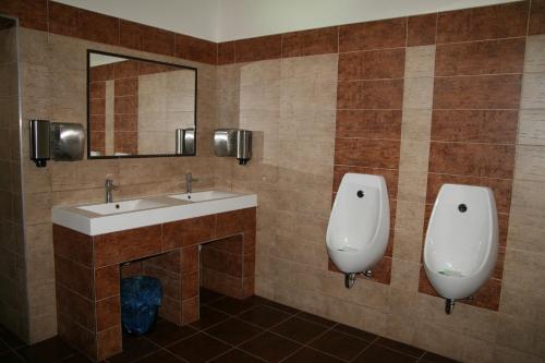 a bathroom with two urinals and a sink and a mirror at Penzion Hvězda - Restaurace dočasně uzavřena in Rumburk