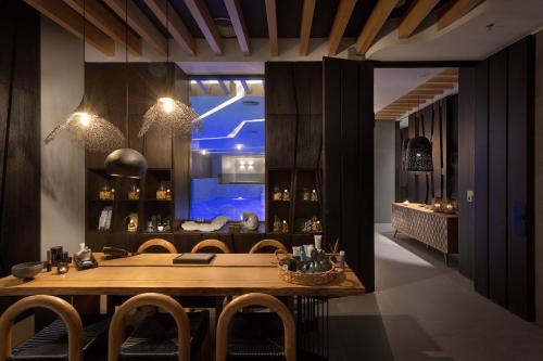 a dining room with a wooden table and chairs at Olympic Palace Hotel in Ixia