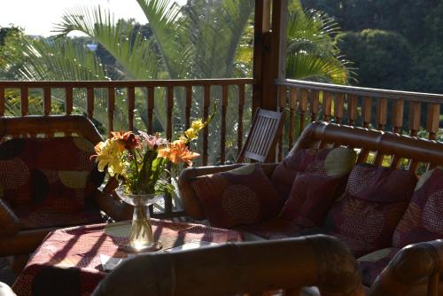 a table with a vase of flowers on a porch at Villa Des Remparts in Sainte-Marie