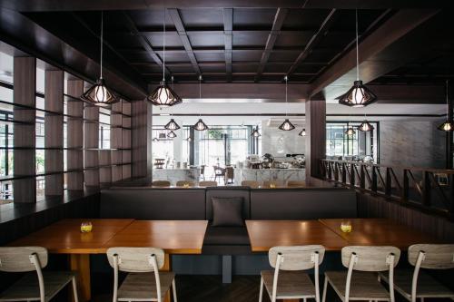 a restaurant with two wooden tables and chairs at Diamond Park Inn Chiangrai & Resort in Chiang Rai