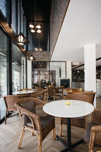 a restaurant with a white table and chairs at Diamond Park Inn Chiangrai & Resort in Chiang Rai