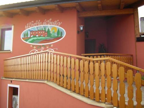a house with a staircase and a sign on the wall at B&B COLLE DI CONDRO in Serrastretta