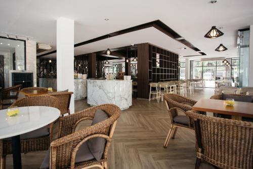 a restaurant with tables and chairs and a bar at Diamond Park Inn Chiangrai & Resort in Chiang Rai