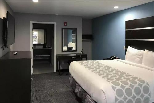 a hotel room with a large bed and a desk at Rodeway Inn South in Calhoun