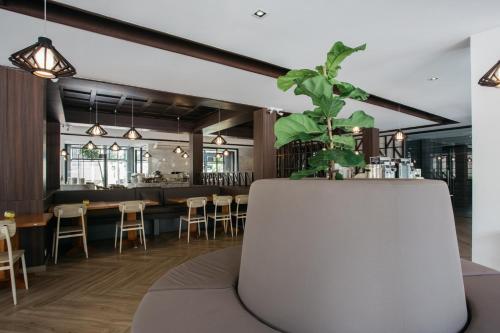a restaurant with a plant in the center of the room at Diamond Park Inn Chiangrai & Resort in Chiang Rai
