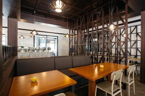 a restaurant with two wooden tables and chairs at Diamond Park Inn Chiangrai & Resort in Chiang Rai