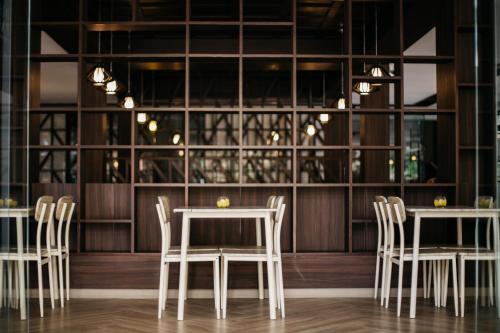 a dining room with white tables and chairs at Diamond Park Inn Chiangrai & Resort in Chiang Rai
