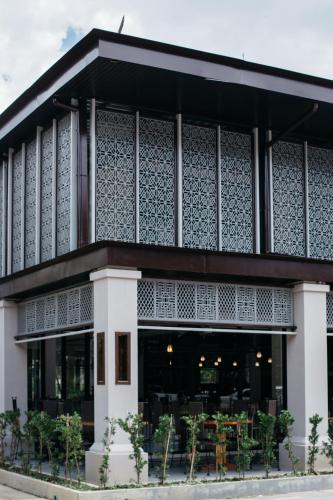 a building with a cafe in front of it at Diamond Park Inn Chiangrai & Resort in Chiang Rai