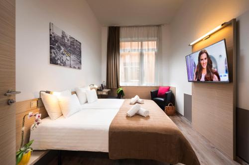 a bedroom with a bed, television and a painting on the wall at Bo18 Hotel Superior in Budapest
