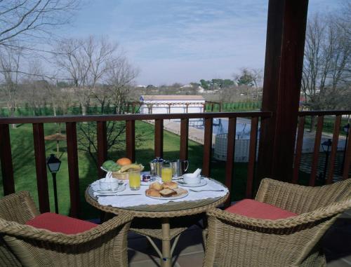 a table with a plate of food on a balcony at Parador de Manzanares in Manzanares