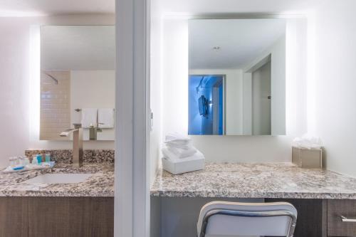 Hibiscus Suites - Sarasota في ساراسوتا: حمام مع حوض ومرآة